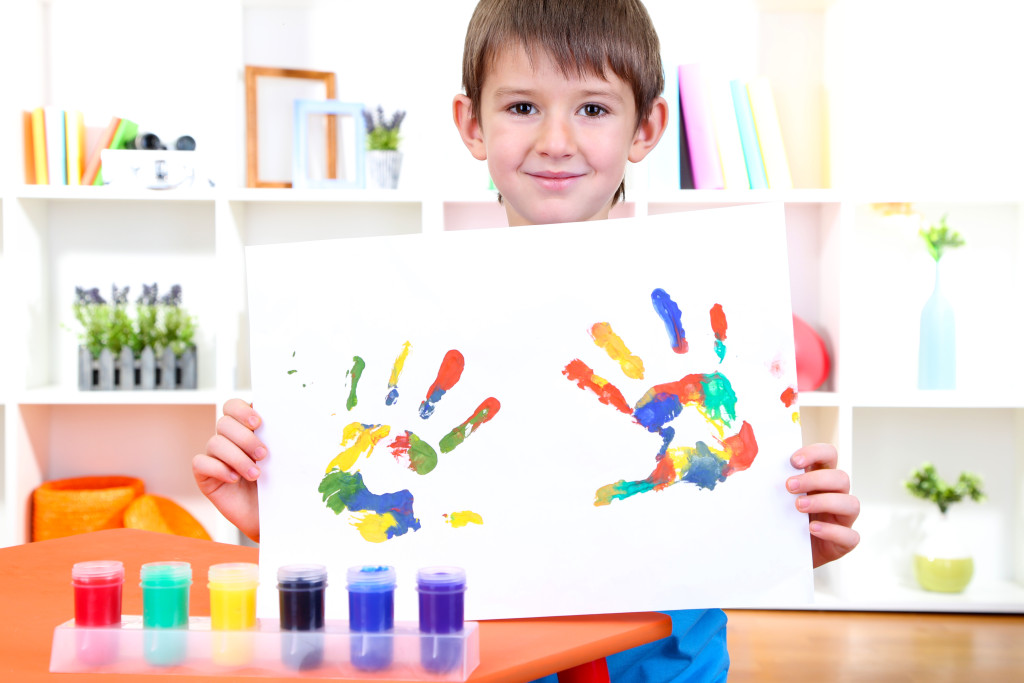 Cute little boy with his colorful handprint
